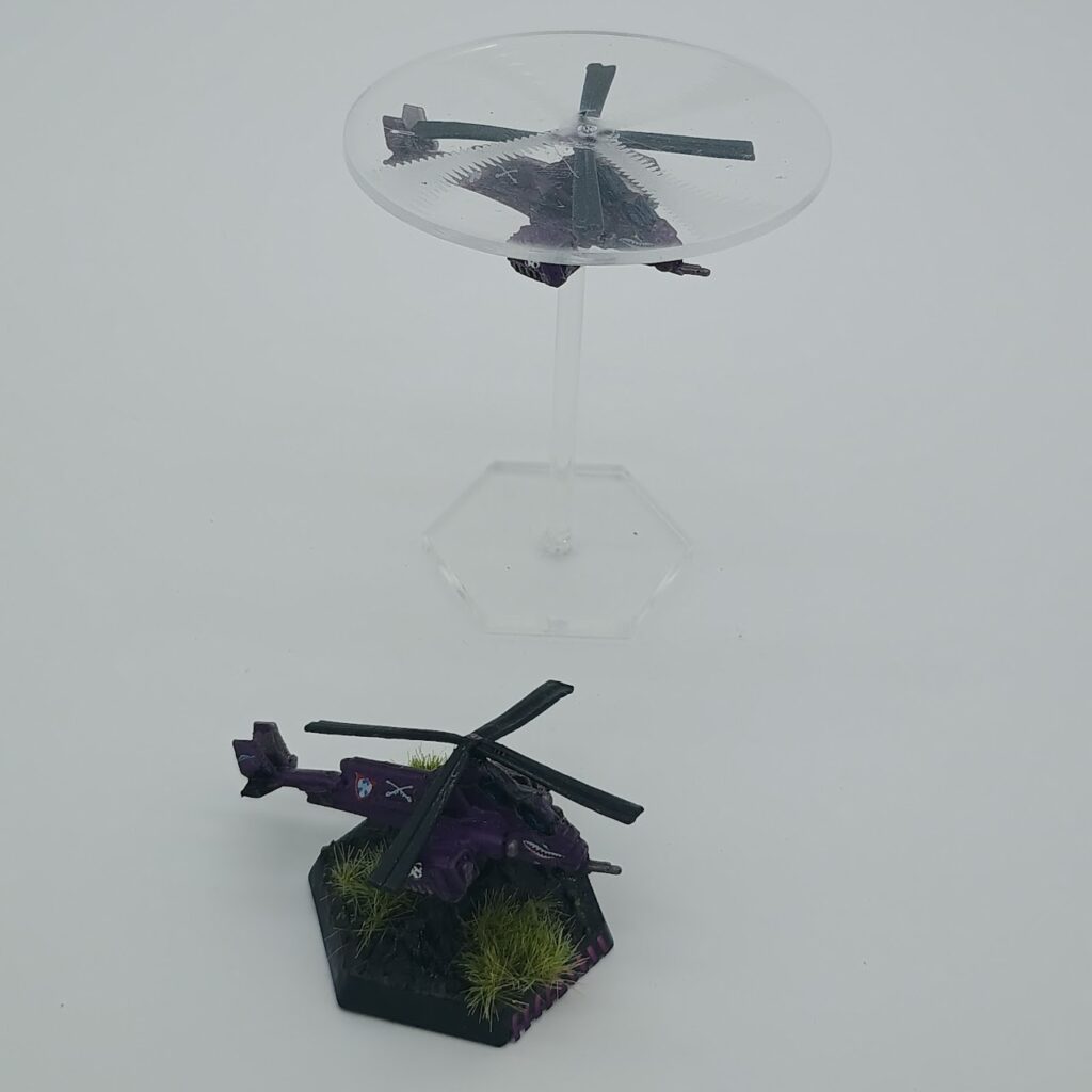 two miniatures of Balac VTOLs, silver on the left and purple on the right