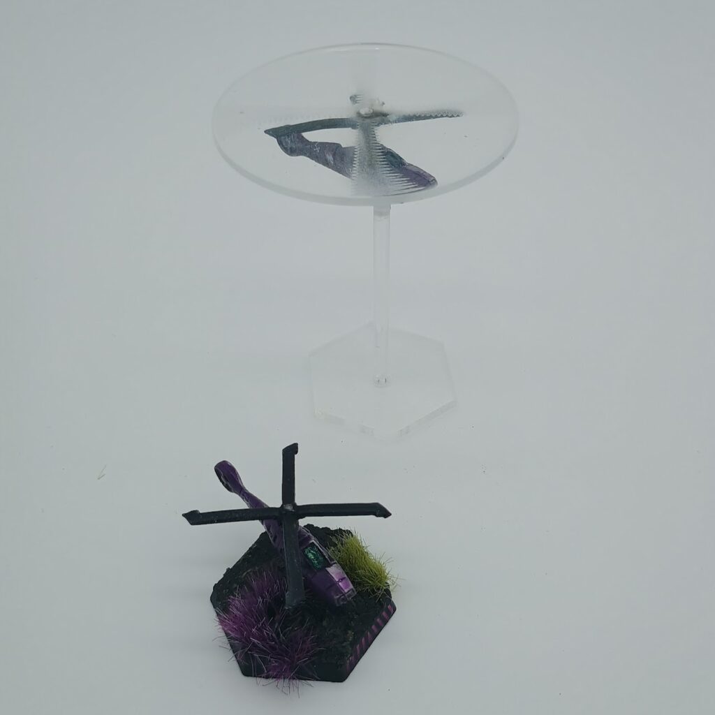 two miniatures of Cavalry VTOLs, silver on the left and purple on the right