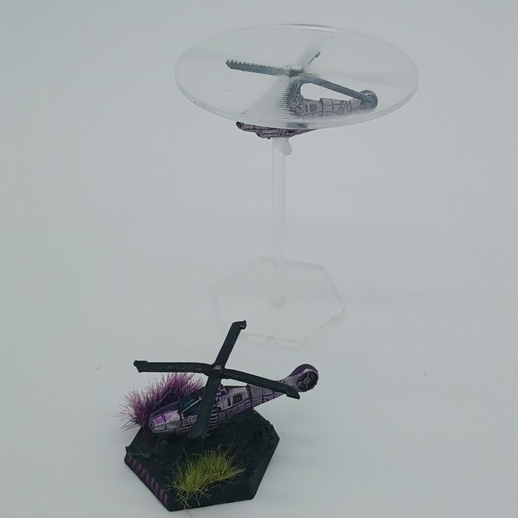 two miniatures of Cavalry VTOLs, silver on the left and purple on the right