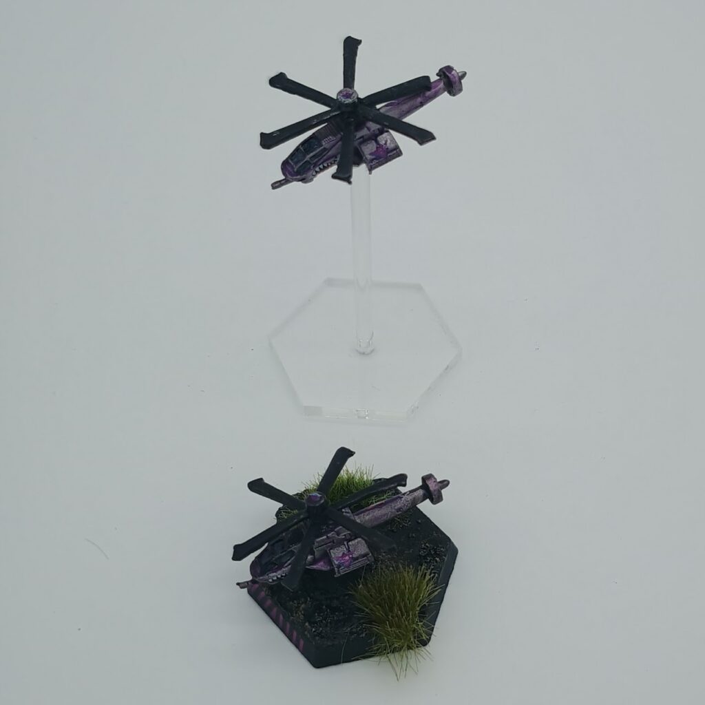 two miniatures of Warrior VTOLs, silver on the left and purple on the right