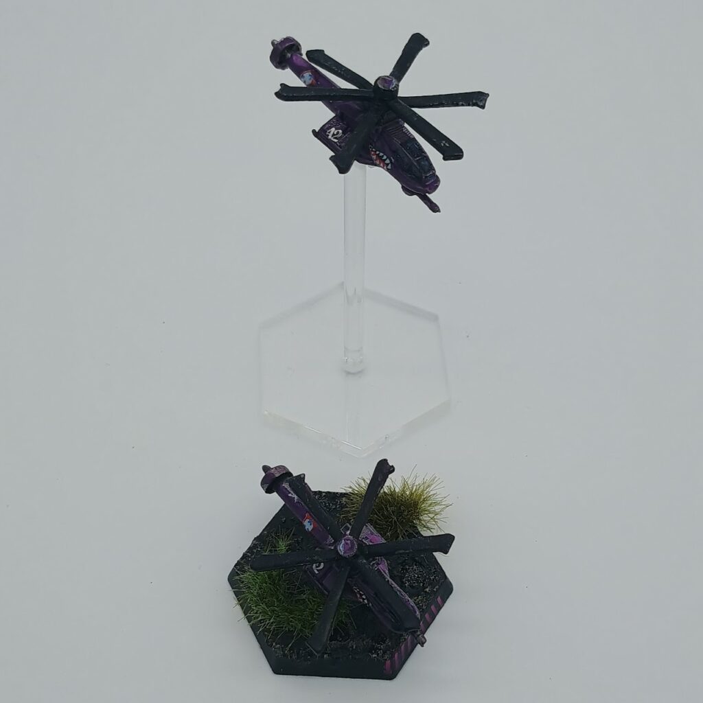 two miniatures of Warrior VTOLs, silver on the left and purple on the right