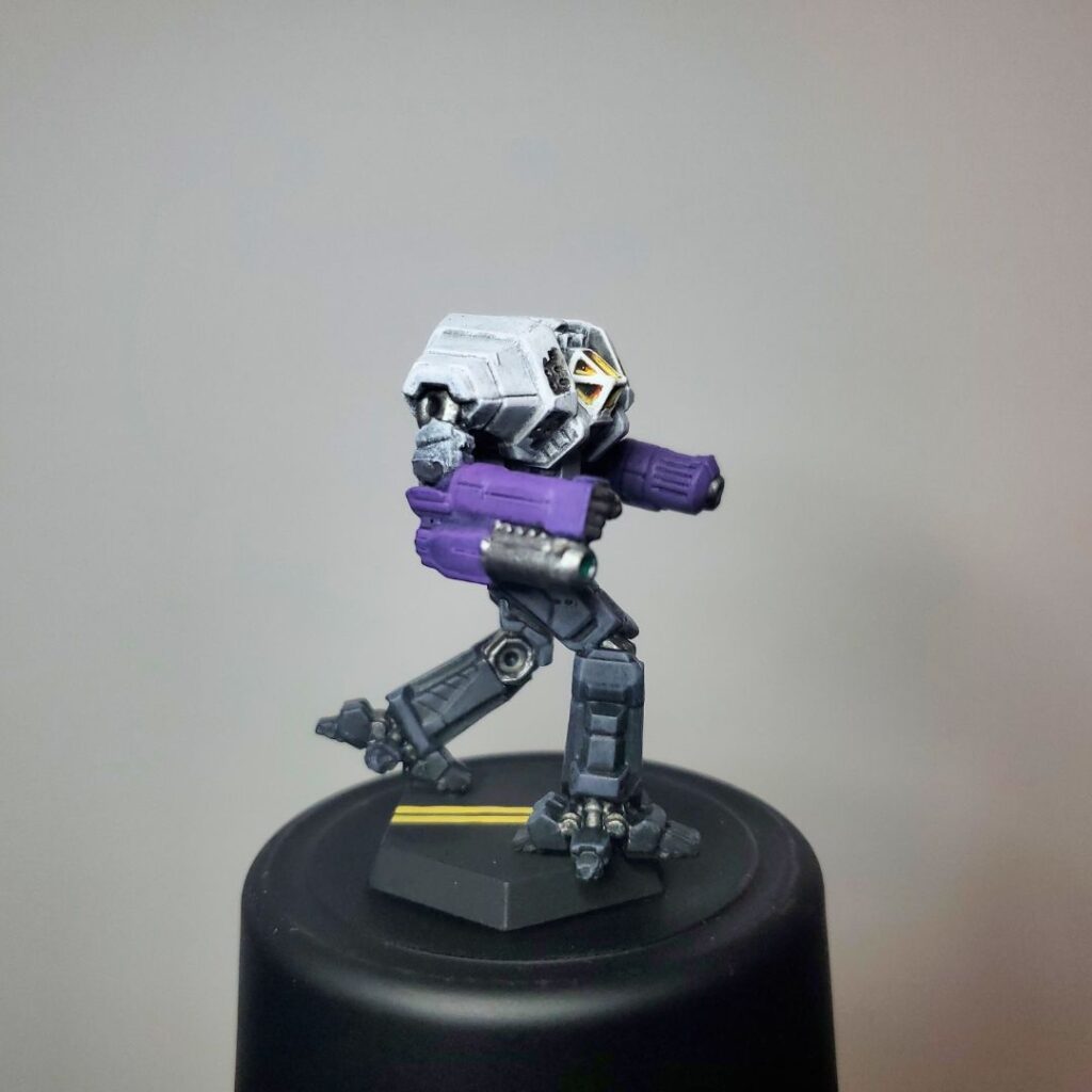 an Ymir miniature painted grey with white, black, and purple accents