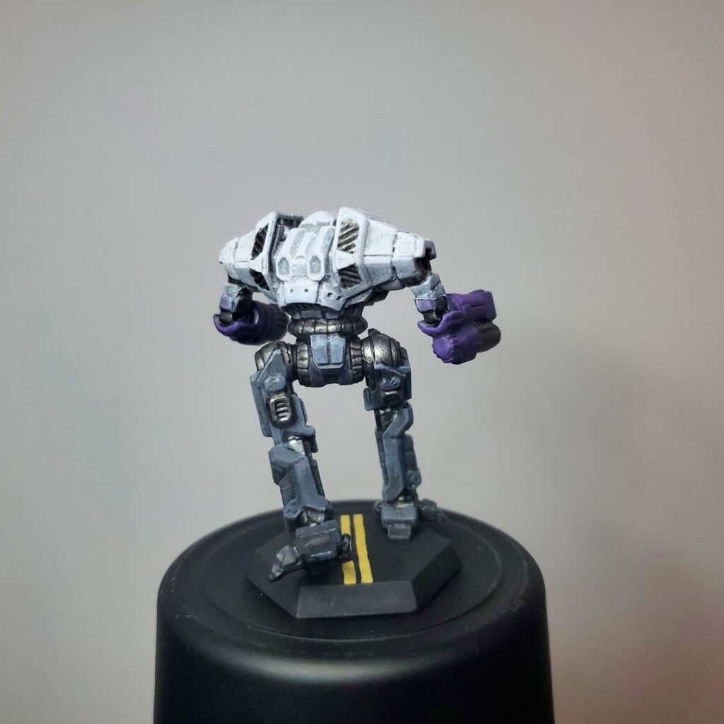 an Ymir miniature painted grey with white, black, and purple accents