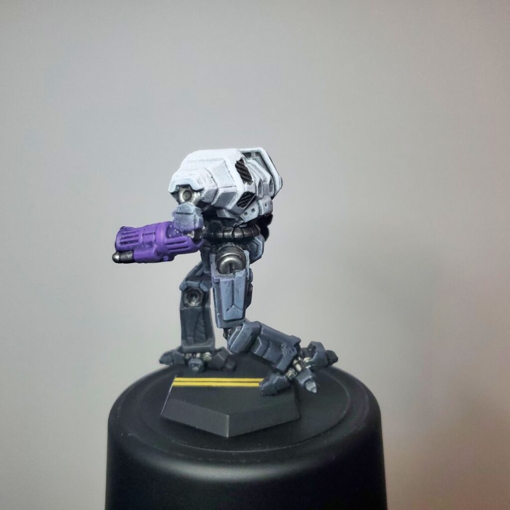 an Ymir miniature painted grey with white, black, and purple accents